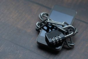 Giyilebilir Cihazlarda Sağlık Verisi Gizliliği: Verileriniz Kimde? Zincir ve kilitle korunan telefon