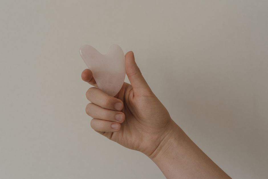 Elinde gua sha taşı tutan bir kişi