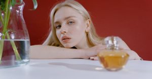 Güneşte Parfüm Leke Yapar mı? Bergamot ve Fototoksik İçerikler Güneş ışığı altında bileğe parfüm sıkan kişinin yakın çekimi