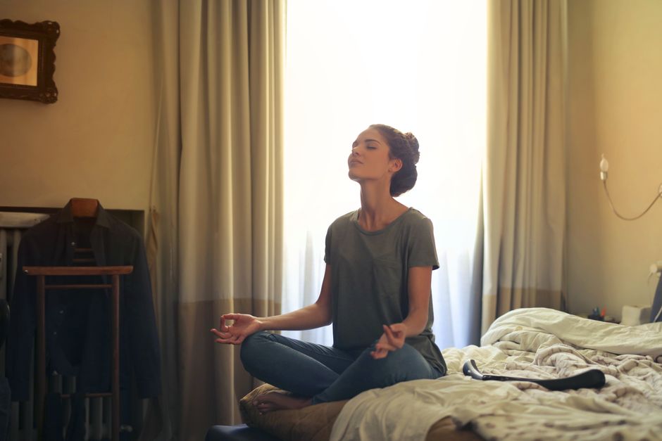 Yatakta meditasyon yapan kadın