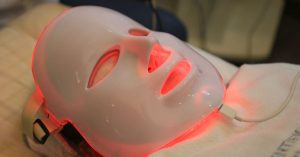 LED Maske: Kırmızı ve Mavi Işık Cilde Ne Yapar? Yüzünde kırmızı ışık yayan LED terapi maskesi takan kişi